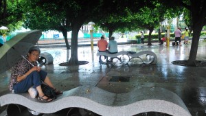 Cina, Beihai. Al riparo dalla pioggia nella piazza principale.