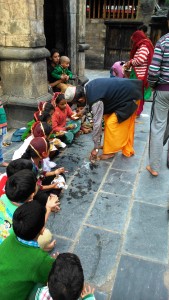 Bharmour,dopo la puja, il prete regala dei soldi spiccioli ad ogni bambino dopo aver ricoperto il capo delle bambine.