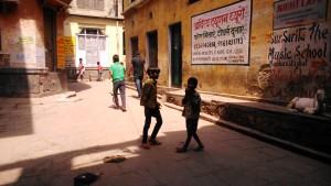 Varanasi, interni del Manikanika Ghat. Bambini che non frequentano la scuola e giocano a cricket in un piazzale.
