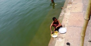 Varanasi, nei pressi del Shindhia Ghat. Bambino che dà da mangiare al Gange.