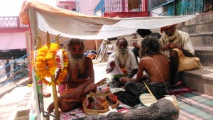Varanasi, sadhu che fumano sotto un riparo dal sole.